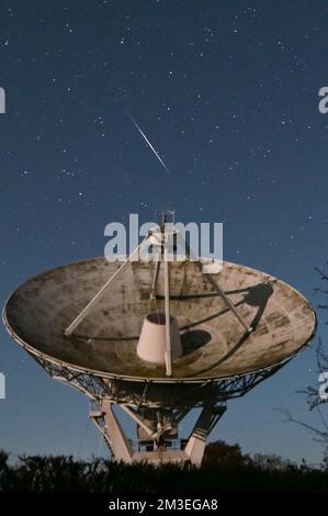 Knockin, Shropshire - 14 décembre 2022 - Un météore filme devant le radiotélescope Knockin dans le Shropshire pendant le pic de la douche de météore des Geminidés de mercredi soir à jeudi matin. Geminids est l'une des douches les plus actives avec jusqu'à 120 par heure. Le radiotélescope Knockin, près d'Oswestry, fait partie d'un réseau géré par l'Observatoire de Jodrell Bank de renommée internationale à Cheshire. Crédit : Scott cm/Alay Live News Banque D'Images