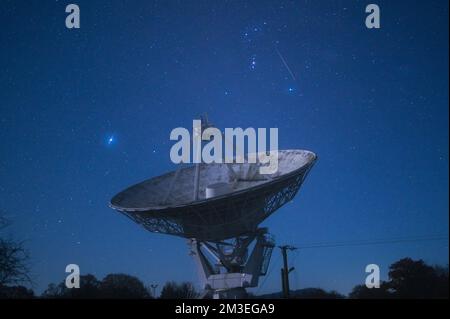 Knockin, Shropshire - 14 décembre 2022 - Un météore filme devant le radiotélescope Knockin dans le Shropshire pendant le pic de la douche de météore des Geminidés de mercredi soir à jeudi matin. Geminids est l'une des douches les plus actives avec jusqu'à 120 par heure. Le radiotélescope Knockin, près d'Oswestry, fait partie d'un réseau géré par l'Observatoire de Jodrell Bank de renommée internationale à Cheshire. Crédit : Scott cm/Alay Live News Banque D'Images