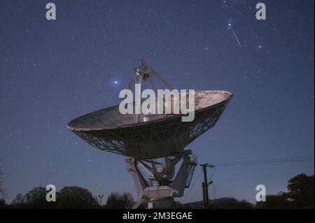 Knockin, Shropshire - 14 décembre 2022 - Un météore filme devant le radiotélescope Knockin dans le Shropshire pendant le pic de la douche de météore des Geminidés de mercredi soir à jeudi matin. Geminids est l'une des douches les plus actives avec jusqu'à 120 par heure. Le radiotélescope Knockin, près d'Oswestry, fait partie d'un réseau géré par l'Observatoire de Jodrell Bank de renommée internationale à Cheshire. Crédit : Scott cm/Alay Live News Banque D'Images