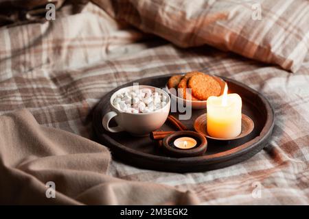 intérieur chaleureux et confortable de la chambre avec une tasse de chocolat chaud sur le plateau, bougies Banque D'Images