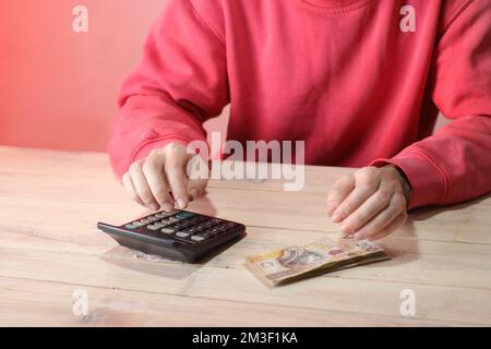 comptage des billets de banque polonais avec calculatrice sur table et fond de couleur Banque D'Images