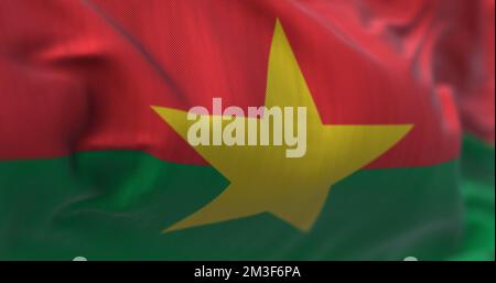 Vue rapprochée du drapeau national du Burkina Faso qui agite dans le vent. Le Burkina Faso est un pays d'Afrique de l'Ouest. Arrière-plan texturé en tissu. Sélectif FO Banque D'Images