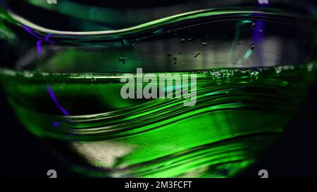 Le concept d'un barman . Clip . Des boissons à feu vert vif dans un grand verre qui sont versés pour boire . 4K images de haute qualité Banque D'Images