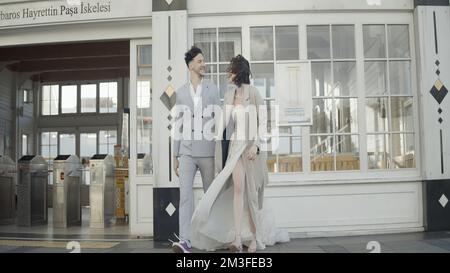 Un couple élégant et heureux en costume. Action. Un beau couple rit dans la rue de la ville. Ensemble élégant et souriant. Banque D'Images