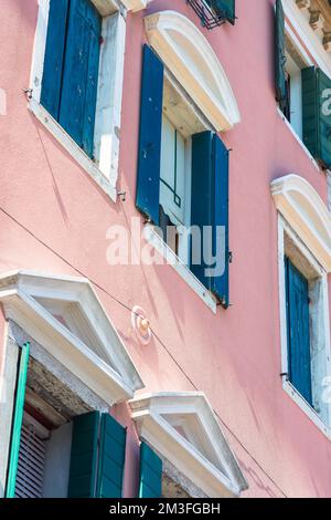 Maison rose, détail d'une élégante maison de ville rose avec des volets bleus dans le Corso del Popolo dans la pittoresque ville vénitienne de Chioggia, Vénétie, Italie Banque D'Images