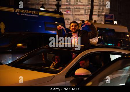 Paris, France. 15th décembre 2022. Un Français colle la moitié de son corps au-dessus de la voiture avec un drapeau français sur l'Arc de Triomphe à Paris lors des célébrations de qualification de la France pour la finale de la coupe du monde au Qatar. Émeutes au coeur de Paris après la victoire demi-finale de la France sur le Maroc au Qatar. Plus de 5 000 soldats de la gendarmerie ont été stationnés près de l'Arc de Triomphe à Paris pour disperser les fanatiques qui étaient à l'origine d'incidents violents le soir. Crédit : SOPA Images Limited/Alamy Live News Banque D'Images