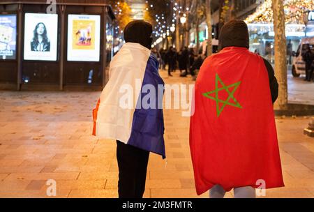 Paris, France. 14th décembre 2022. Deux supporters de football, l'un drapé d'un drapeau français et l'autre avec un drapeau marocain, se promènaient le long des champs-Élysées lors du match de demi-finale de la coupe du monde. Émeutes au coeur de Paris après la victoire demi-finale de la France sur le Maroc au Qatar. Plus de 5 000 soldats de la gendarmerie ont été stationnés près de l'Arc de Triomphe à Paris pour disperser les fanatiques qui étaient à l'origine d'incidents violents le soir. Crédit : SOPA Images Limited/Alamy Live News Banque D'Images