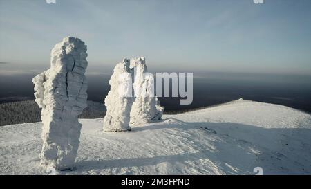 Vue aérienne de formations de pierres enneigées à couper le souffle sur un fond bleu ciel nuageux. Attache. Hiver en montagne Banque D'Images