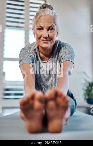Oh bonjour là-bas. Portrait d'une femme gaie et mûre pratiquant le yoga dans un studio pendant la journée. Banque D'Images