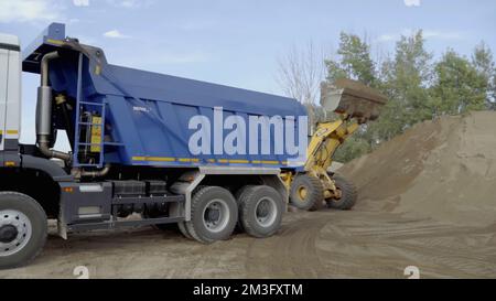 Berlin, Allemagne - 20 juin 2022 : différentes machines travaillent dans une carrière de pierre. Scène. Expérience industrielle avec des tracteurs et des camions chargeant des pierres et des Banque D'Images
