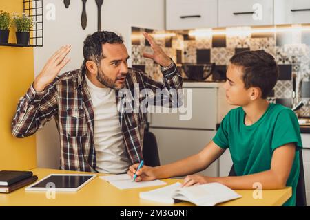 Le père aide son fils à apprendre. Ils font leurs devoirs ensemble. Banque D'Images