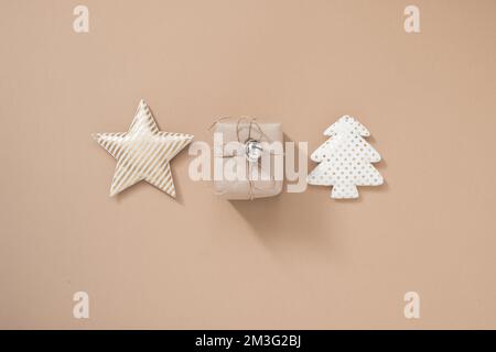 Composition de Noël. Boîte cadeau de Noël, étoile et sapin de noël sur fond beige pastel Banque D'Images