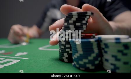 Jeu de hasard de pari. Action. Gros plan de l'homme mettant des jetons sur la table de poker. L'homme fait un pari avec des jetons sur le poker. Banque D'Images