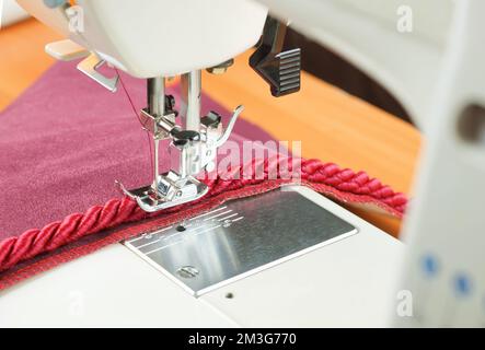 aiguille de machine à coudre et cordon de bordure décoratif. processus de fixation. Banque D'Images