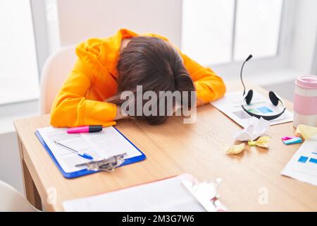 Femme d'âge moyen travailleur d'affaires stressé avec la tête sur la table au bureau Banque D'Images