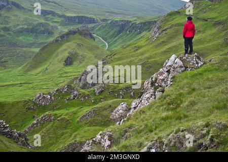 Veste d'extérieur rouge de randonnée dans le monde de rock bizarre de Quiraing, Trotternish Ridge, Highlands, Isle of Skye, Hebrides intérieures, Écosse, Grande-Bretagne Banque D'Images