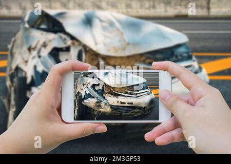 femme utilisant un smartphone prendre une photo de l'accident de voiture sur la route Banque D'Images