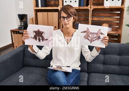 Brunette femme travaillant avec le test de rorschach à la clinique de psychologie expression sans indice et confuse. notion de doute. Banque D'Images
