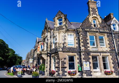 L'hôtel Victoria de Bamburgh, un village côtier de Northumberland sur la côte nord-est de l'Angleterre, les clients buvant dehors lors d'une journée ensoleillée Banque D'Images