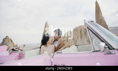 Photo élégante des jeunes mariés. Action.Une belle fille mince dans une robe longue blanche avec son homme posant pour la caméra sur la rue à côté de t Banque D'Images