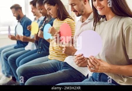 Groupe de personnes diverses prenant part à l'enquête d'opinion et montrant des bulles de discours de maquette Banque D'Images