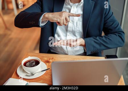 Les hommes d'affaires ont une réunion d'affaires par appel vidéo et communiquent en utilisant le langage des signes dans le café Banque D'Images