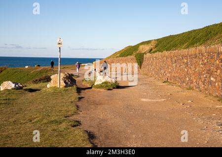 Newquay,Cornwall,15th décembre 2022, les gens appréciant le soleil glorieux lors d'une belle journée ensoleillée mais très froide à Fistral Beach, Cornwall. La plage est célèbre car les gens voyagent de tout le pays pour monter sur les célèbres vagues avec de grandes conditions de surf.Credit: Keith Larby/Alay Live News Banque D'Images