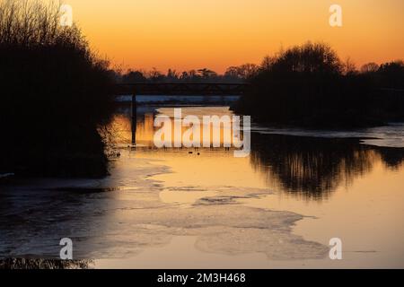 Dorney, Buckinghamshire, Royaume-Uni. 15th décembre 2022. Après un autre jour de températures inférieures à zéro, le soleil se couche sur la rivière Jubilee à Dorney, qui a maintenant une quantité considérable de glace de surface. La rivière Jubilee est un programme de réduction des crues qui protège Windsor, Eton et Maidenhead en cas d'inondation. C'est aussi un refuge pour les oiseaux migrateurs. Crédit : Maureen McLean/Alay Live News Banque D'Images