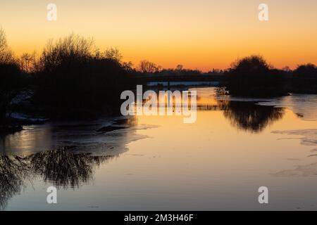 Dorney, Buckinghamshire, Royaume-Uni. 15th décembre 2022. Après un autre jour de températures inférieures à zéro, le soleil se couche sur la rivière Jubilee à Dorney, qui a maintenant une quantité considérable de glace de surface. La rivière Jubilee est un programme de réduction des crues qui protège Windsor, Eton et Maidenhead en cas d'inondation. C'est aussi un refuge pour les oiseaux migrateurs. Crédit : Maureen McLean/Alay Live News Banque D'Images