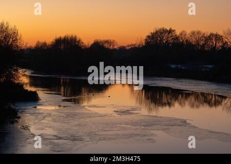 Dorney, Buckinghamshire, Royaume-Uni. 15th décembre 2022. Après un autre jour de températures inférieures à zéro, le soleil se couche sur la rivière Jubilee à Dorney, qui a maintenant une quantité considérable de glace de surface. La rivière Jubilee est un programme de réduction des crues qui protège Windsor, Eton et Maidenhead en cas d'inondation. C'est aussi un refuge pour les oiseaux migrateurs. Crédit : Maureen McLean/Alay Live News Banque D'Images