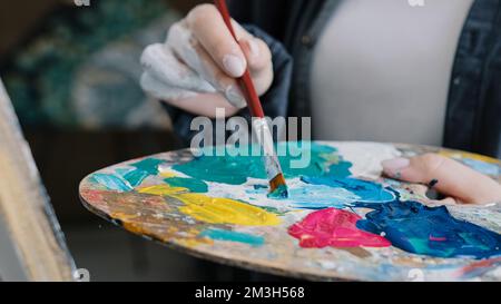 Gros plan femme femme main artiste peintre peintures dessine créer de nouveaux travaux d'art sur toile dans atelier leçon de peinture apprécier le processus de dessin Banque D'Images