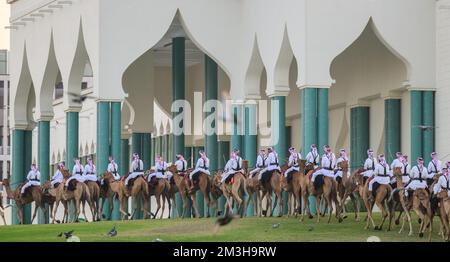 Doha, Qatar. 15th décembre 2022. 15 décembre 2022, Qatar, Doha: Les forces de sécurité montées montent leurs chameaux le long d'un pré devant l'Amiri Diwan, le lieu de travail officiel et le bureau de l'émir de l'État du Qatar. La coupe du monde 2022 se termine le 18.12.2022 avec la finale entre l'Argentine et la France. Photo: Robert Michael/dpa - NOTE IMPORTANTE: Conformément aux exigences du DFL Deutsche Fußball Liga et du DFB Deutscher Fußball-Bund, il est interdit d'utiliser ou d'avoir utilisé des photos prises dans le stade et/ou du match sous forme de séquences d'images et/ou de séries de photos de type vidéo Banque D'Images