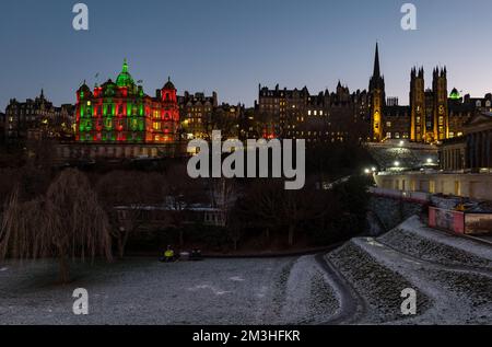 Édimbourg, Écosse, Royaume-Uni, 15th décembre 2022. Noël : le siège social de la Bank of Scotland (Lloyds Banking), situé sur le Mound, et la salle d'assemblée de l'église d'Écosse sont illuminés au crépuscule dans des lumières colorées à l'heure de Noël avec de la neige sur le sol dans Princes Street Gardens. Crédit : Sally Anderson/Alay Live News Banque D'Images