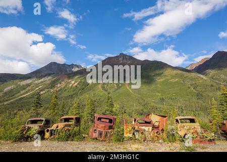 Une gamme de camions rouillés abandonnés après la guerre qui rouillent dans le désert pendant l'été dans le nord du Canada Banque D'Images