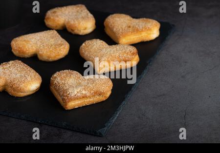 Biscuits en forme de coeur sur la planche à découper Banque D'Images