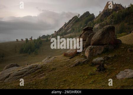 Petites maisons sur le matin brumeux entouré d'arbres sur la crête de la montagne. Petites huttes sur la crête de la colline par un jour brumeux. Banque D'Images