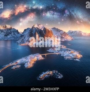 Vue aérienne de l'arche de la voie lactée, de la mer, du village et des montagnes enneigées Banque D'Images