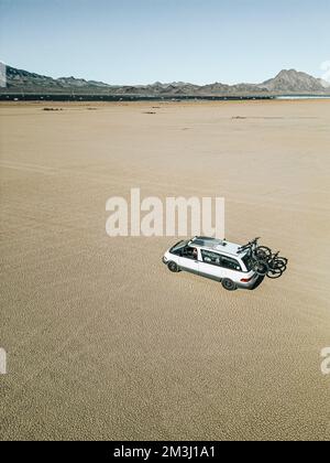 Vue aérienne d'un véhicule de loisirs autoconverti de camping-car roulant sur un lit de lac sec dans le désert du sud du nevada des États-Unis avec panneau solaire Banque D'Images