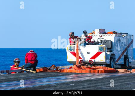 221214-N-PA221-2206 OCÉAN PACIFIQUE (14 DÉCEMBRE 2022) ÉTATS-UNIS Les marins de la Marine effectuent l'entretien d'un tuyau d'incendie sur le pont de vol du porte-avions USS Nimitz (CVN 68). Nimitz mène actuellement des opérations de routine. (É.-U. Photo de la marine par le spécialiste des communications de masse 3rd classe Kevin Tang) Banque D'Images