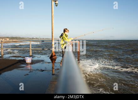 garçon avec son filet de pêche à la pêche pour les crabes dans la mer Banque D'Images