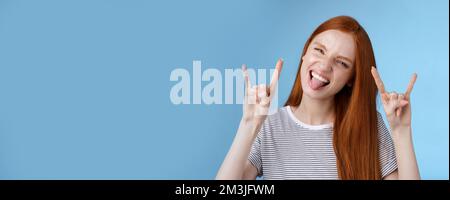 Oser insouciance ludique excitée bonne-regardant drôle redhead fille ayant le plaisir montrez l'affaissement de la languette faites de la grimace ravie faire du métal lourd rock-n-roll signe Banque D'Images