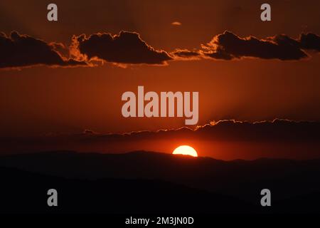 Le soleil descend derrière les montagnes pendant un coucher de soleil d'hiver pour apprécier le paysage dans la région montagneuse de Tepoztlan. Banque D'Images