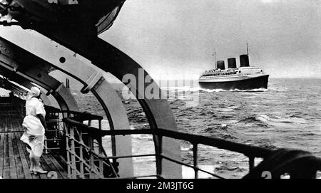 Photographie du paquebot français de luxe, 'Normandie', dans l'Atlantique lors de son premier voyage, vu depuis le pont de la 'Champlain'. Le 'Normandie' a remporté le Blue Riband assez facilement lors de ce voyage, avec un temps de traversée de 4 jours et trois heures. 1935 Banque D'Images