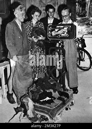 Photographie montrant plusieurs citoyens de Berlin-Ouest apportant leurs vieux vêtements en laine dans un dépôt de vêtements d'occasion, Berlin, août 1948. Les vêtements ont été pesés, puis des permis ont été délivrés pour l'achat de nouveaux vêtements d'un poids équivalent. Le blocus soviétique de Berlin-Ouest a signifié que les pénuries de tous les consommables étaient inévitables. Entre avril 1948 et mai 1949, Josef Staline, chef de l'URSS, a imposé un blocus terrestre sur les approvisionnements de l'Europe occidentale à Berlin-Ouest. En réponse, les gouvernements britannique et américain ont organisé un énorme pont aérien pour fournir de la nourriture et d'autres éléments essentiels Banque D'Images