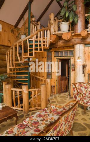 Escalier en spirale dans le salon à l'intérieur de la cabane rustique en rondins. Banque D'Images