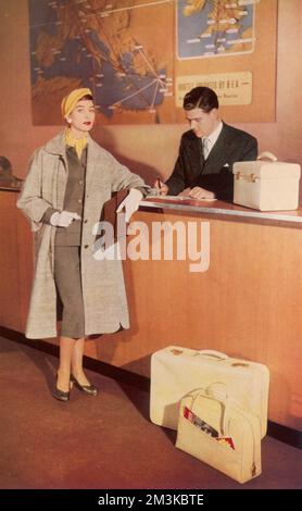 Le manteau de voyage idéal : ample, confortable et suffisamment spacieux pour s'adapter à n'importe quel costume ; tweed à carreaux gris clair à deux tons - manches raglan profondes avec poignets incurvés et ourlet. Présenté sur un costume Uni gris foncé et porté avec un béret en velours jaune, tous disponibles chez Harrods. C'est le genre d'otufit pour un voyageur élégant comme cette dame, qui s'est posé contre un comptoir d'enregistrement à l'aéroport de British European Airways. Date: 1956 Banque D'Images