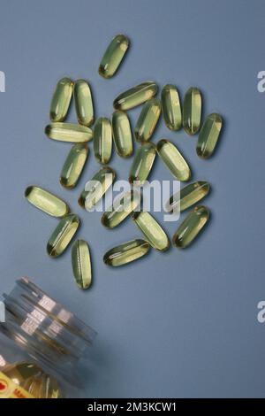 vue de dessus des capsules d'huile de poisson et de la bouteille sur fond bleu Banque D'Images