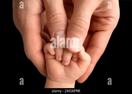 gros plan, main de bébé tenant le doigt d'un parent, symbole d