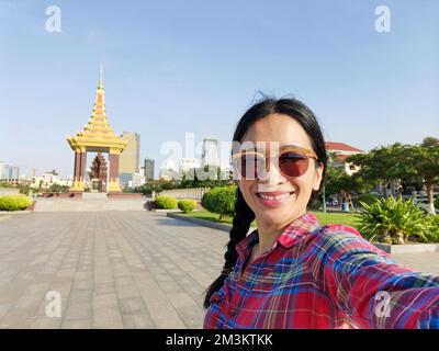 Une jeune touriste asiatique prend un selfie à la statue du Roi Père Norodom Sihanouk Memorial à Phnom Penh, au Cambodge. Banque D'Images