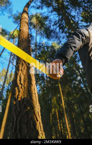 Scène de crime.signes et symboles. Ruban d'interdiction de protection jaune dans une forêt.Homme clôture scène de crime avec ruban jaune.signes et symboles Banque D'Images